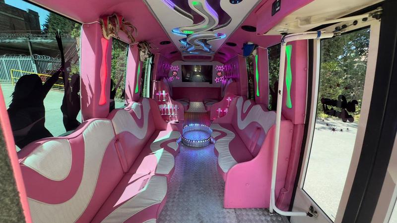 Pink party bus interior - full view with LED lighting and premium seating